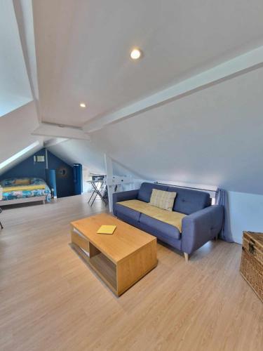 a living room with a blue couch and a coffee table at Le Petit Langlet - Cathedral - hyper-center in Reims