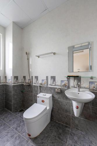 a bathroom with a toilet and a sink at LOMO house in Khu Chi Lăng