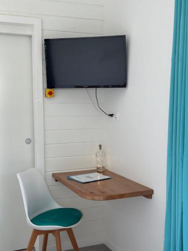 a room with a chair and a tv on a wall at Iguane House Villas & Micro Spa in Sainte-Anne