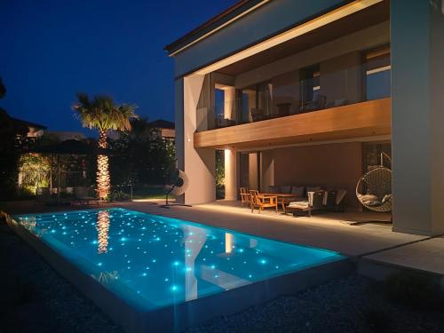 a house with a swimming pool at night at Almyros Beach in Acharavi