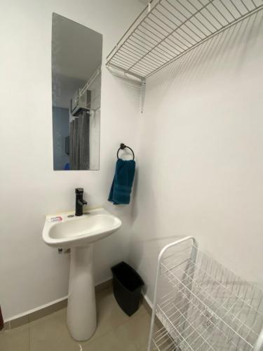 a white bathroom with a sink and a mirror at Hostal TO3 in Ciudad Madero