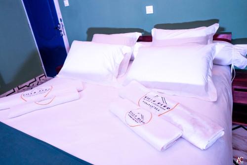 two beds with white sheets and pillows with tags on them at Cléo Hôtel-Restaurant in Fianarantsoa