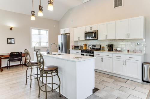 a kitchen with white cabinets and a table and chairs at Dock and Backyard Bar Spacious Barnegat Bay Retreat in Waretown