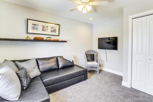a living room with a leather couch and a tv at Dock and Backyard Bar Spacious Barnegat Bay Retreat in Waretown