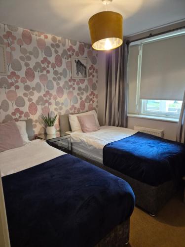 a bedroom with two beds and a window at 2 bed GF Docklands Apartment - Free Parking for 1 car in Liverpool