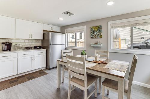 a kitchen with a table and chairs and a refrigerator at Dock and Backyard Bar Spacious Barnegat Bay Retreat in Waretown
