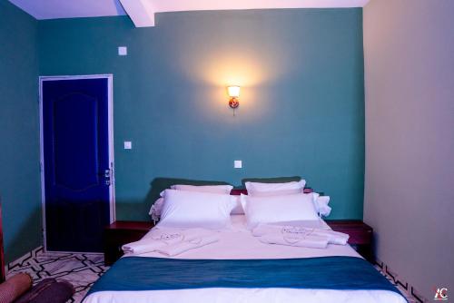 a bedroom with a bed with a blue wall at Cléo Hôtel-Restaurant in Fianarantsoa