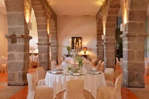 a table set up for a wedding in a large room with columns at Pousada Mosteiro de Guimaraes in Guimarães