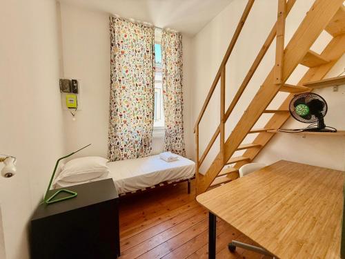 Cette petite chambre comprend un lit et un escalier. dans l'établissement Rozane by Yumē, à Toulouse