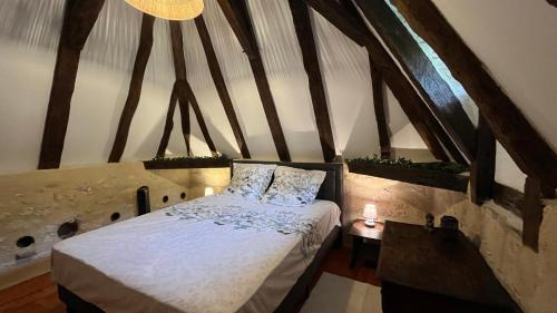 a bedroom with a bed in an attic at Pigeonnier de Claire Fontaine in Monflanquin