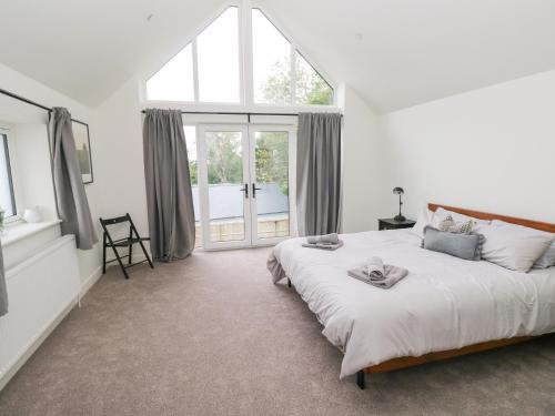 a bedroom with a large bed and a large window at Ty Landsker in Milford Haven