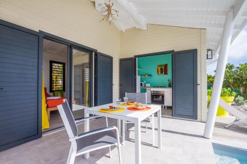 a white table and chairs on a patio at Iguane House Villas & Micro Spa in Sainte-Anne