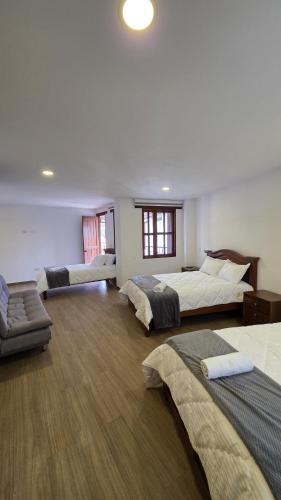 a large room with three beds and a couch at Escencia raquireña in Ráquira