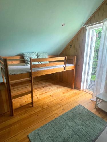 a bedroom with a bunk bed and a large window at Ventlejas in Strakši