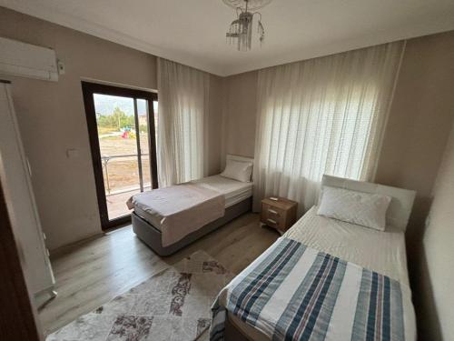 a bedroom with two beds and a window at Keskin Villa Köyceğiz in Koycegiz