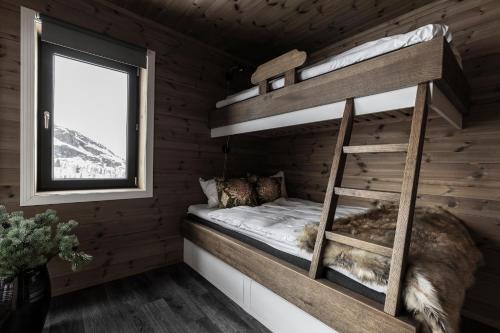a bunk bed in a log cabin with a window at Skigaarden in Hemsedal