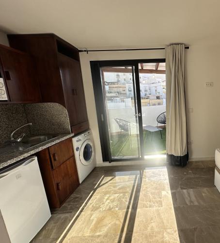 a kitchen with a washer and dryer and a window at Apartamentos El Tranco del Mar in Almuñécar