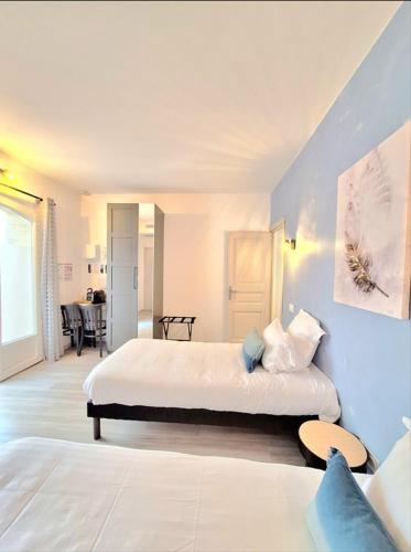 a hotel room with two beds and a table at Domaine de la Mautanne in Sainte-Tulle