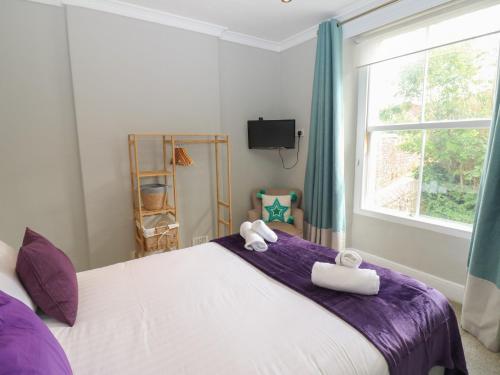 a bedroom with a large bed with towels on it at Hampton House in St Bees