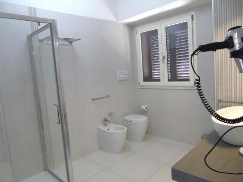 a bathroom with a shower and a toilet and a camera at Areté Luxury Room in Reggio Calabria