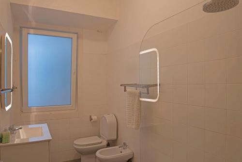 bagno bianco con servizi igienici e finestra di Traditional apartment with garden a Lisbona