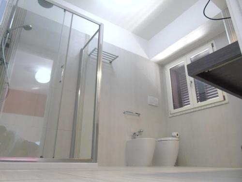 a bathroom with a glass shower and a toilet at Areté Luxury Room in Reggio Calabria