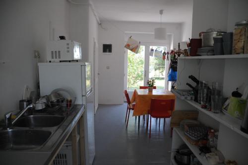 a kitchen with a sink and a table with chairs at Első Ház Tagyon in Tagyon