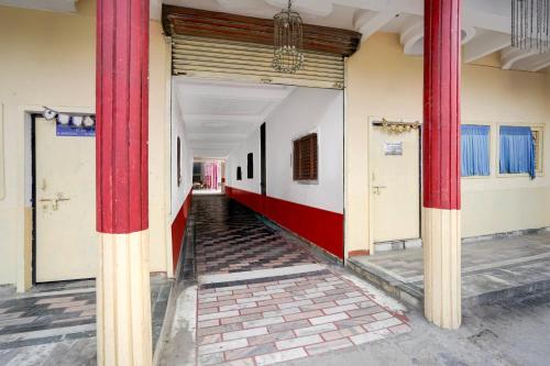 a hallway with red columns in a building at Hotel O Vrindavan Gardan & Hotel in Prayagraj