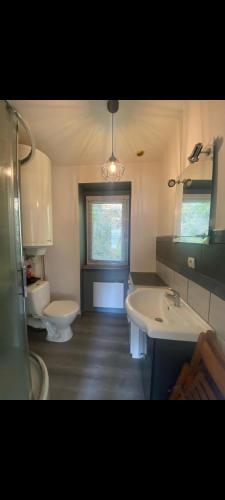a bathroom with two sinks and a toilet and a window at Duplex plage de brehec in Plouézec