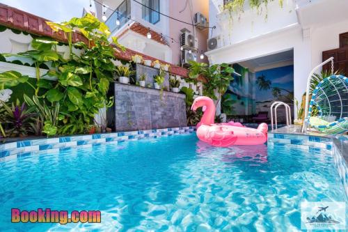 a swimming pool with a pink swan in a building at Nhà Nghỉ Mát Trung Tâm Bãi Sau HM XANH in Vung Tau