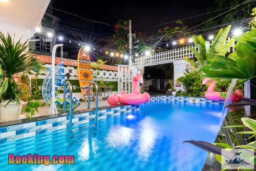 a pool at night with pink flamingos and a water park at Nhà Nghỉ Mát Trung Tâm Bãi Sau HM XANH in Vung Tau