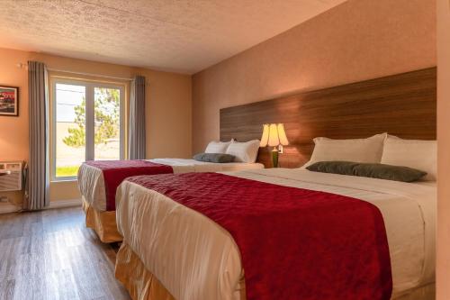 a hotel room with two beds and a window at Hotel Cowansville in Cowansville