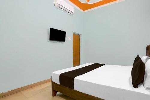 a bedroom with a bed with a tv on the wall at Hotel O HERITAGE HOTEL in Hardoī