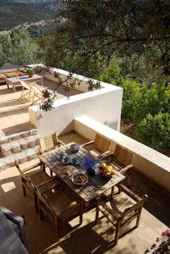 a wooden table and chairs on a patio at Epidaurus Olive Villa in Néa Epídhavros