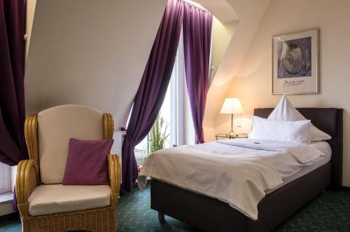 une chambre avec un lit, une chaise et une fenêtre dans l'établissement Hotel Artrium am Park, à Dietzenbach