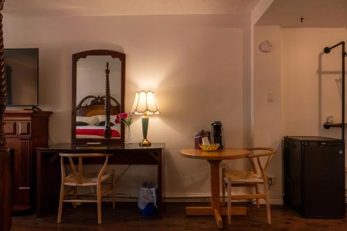 a dining room with a table and a mirror at Hotel Cowansville in Cowansville