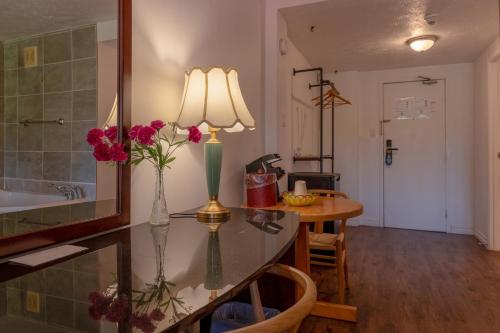 a kitchen with a table with a vase of flowers on it at Hotel Cowansville in Cowansville