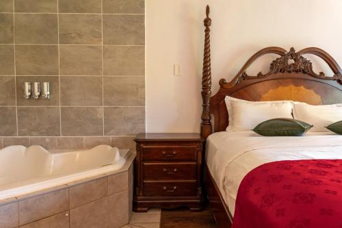 a bedroom with a bed and a bath tub next to at Hotel Cowansville in Cowansville
