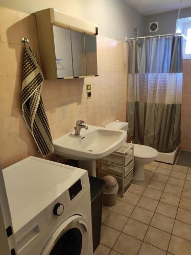 a bathroom with a sink and a washing machine at Gîte L'épinette in Grozon