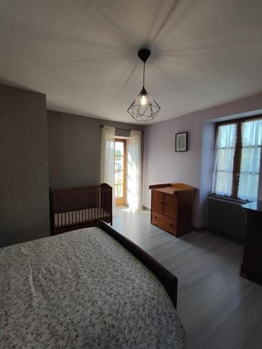 a bedroom with a bed and a dresser and a window at Gîte L'épinette in Grozon