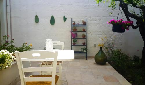 マンドゥーリアにあるCivico 2の花の飾られた部屋の白いテーブルと椅子