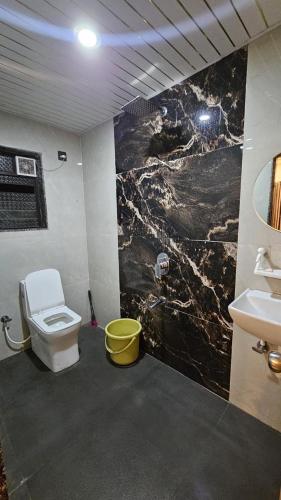 a bathroom with a white toilet and a sink at Roshni guest house in Arpora