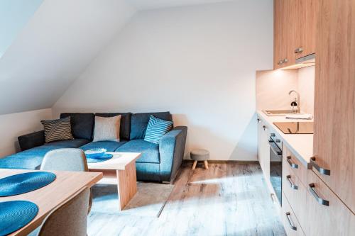 Una sala de estar con un sofá azul y una mesa. en Apartmán Nina, en Dolní Morava