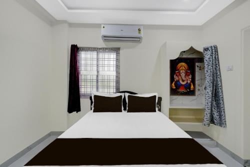 a bedroom with a white bed in a room at Hotel O SR Grand in Bībīnagar