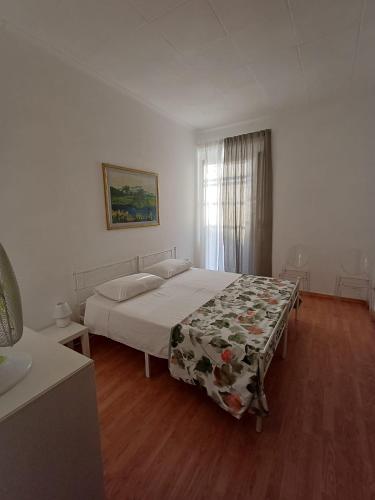 a bedroom with a bed with a floral blanket on it at la gatta bianca in Marino
