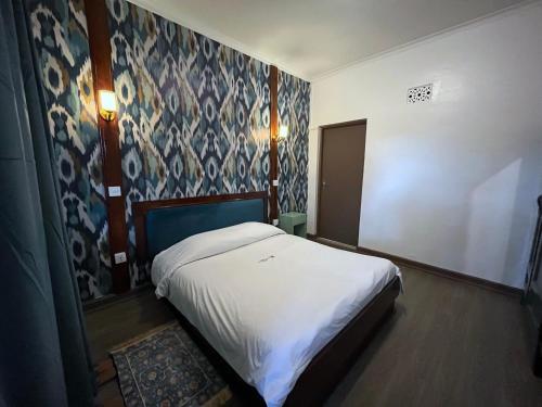 a bedroom with a white bed and a blue wall at KENYA CONTINENTAL Hotel in Nairobi