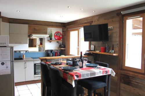 a kitchen with a table with chairs and a counter top at Le Montana - Studio rue du Centre - Cosy et Montagnard - Navette in Les Gets