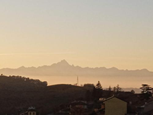 a misty view of a city with mountains in the distance at Casa Tuja in Roddi