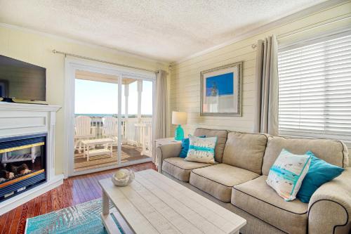 a living room with a couch and a fireplace at Captain's Villa 6-D Our White Pearl in Holden Beach