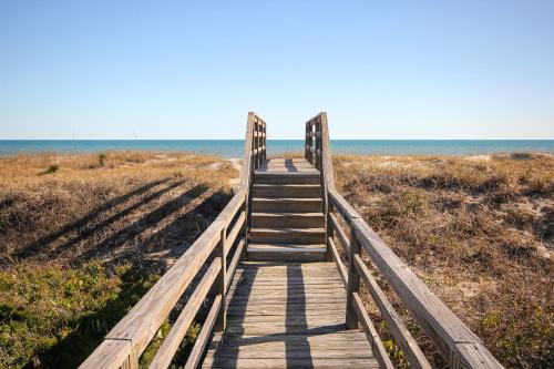 a wooden boardwalk leading to the beach at Captain's Villa 6-D Our White Pearl in Holden Beach